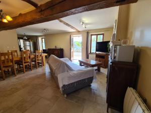 un soggiorno con un letto e una sala da pranzo di Charmant Gîte en Brenne avec Jardin, Piscine Partagée et Proximité Sentiers de Randonnée - FR-1-591-99 a Prissac