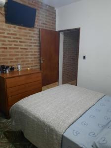 a bedroom with a bed and a dresser and a television at Lo de Milo in Roque Sáenz Peña