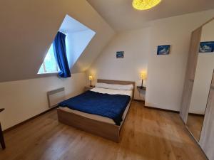 a bedroom with a bed with a blue blanket at Maison paisible avec jardin clos, terrasse, proche lac d'Eguzon et villages médiévaux - FR-1-591-102 in Vigoux