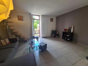 a living room with a couch and a glass table at Charmante maison avec jardin, au cœur du Berry, proche rivière et randonnées - FR-1-591-57 in Chasseneuil