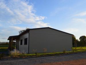 un piccolo edificio grigio sul lato di una strada di Maison éco-responsable avec terrasse, jardin privé et aménagement fauteuil roulant à Pouligny-Saint-Martin - FR-1-591-224 a Pouligny-Saint-Martin