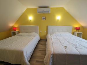 2 Betten in einem Zimmer mit gelben Wänden in der Unterkunft Gîte Villentrois-Faverolles-en-Berry, 3 pièces, 6 personnes - FR-1-591-198 in Villentrois