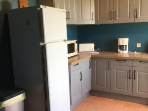 a kitchen with a white refrigerator and a microwave at Charmant Gîte Familial avec Grand Terrain, à Proximité de Fontgombault et de la Creuse - FR-1-591-118 in Sauzelles
