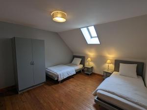 Cette chambre mansardée comprend 2 lits et une lucarne. dans l'établissement Gîte Communauté de communes Brenne - Val de Creuse-Sauzelles, 4 pièces, 8 personnes - FR-1-591-118, à Sauzelles
