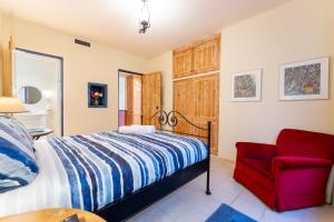 - une chambre avec un lit et une chaise rouge dans l'établissement Casita Alegra Beachfront family friendly, à Port Elliot