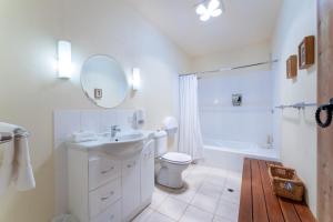 ein Badezimmer mit einem Waschbecken, einem WC und einem Spiegel in der Unterkunft Casita Alegra Beachfront family friendly in Port Elliot
