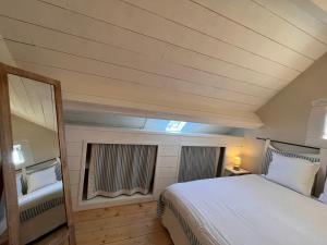 una camera da letto con un letto grande e uno specchio di Gîte en Berry avec jardin, cheminée, jeux enfants - calme assuré en pleine nature - FR-1-591-158 a Sainte-Fauste
