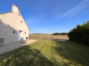 un edificio con un prato accanto a un campo di Gîte en Berry avec jardin, cheminée, jeux enfants - calme assuré en pleine nature - FR-1-591-158 a Sainte-Fauste