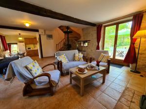 a living room with a couch and a table at Ancien moulin avec piscine, terrasse, jardin privatif et petite île - près des étangs de la Brenne - FR-1-591-159 in Prissac