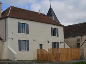 una casa bianca con una recinzione in legno e una chiesa di Presbytère écorénové avec terrasse et vue sur étang, proche Parc Naturel Régional de la Brenne - FR-1-591-180 a Lingé