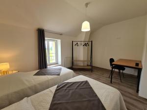 Cette chambre comprend deux lits et un bureau. dans l'établissement Gîte Montierchaume, 6 pièces, 10 personnes - FR-1-591-358, à Montierchaume