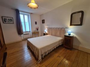 1 dormitorio con cama, espejo y ventana en Gîte Saint-Gaultier, 3 pièces, 6 personnes - FR-1-591-361 en Saint-Gaultier