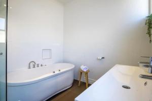 a white bathroom with a tub and a sink at Sorrento Beach Cottages No. 2 - in the heart of Sorrento in Sorrento