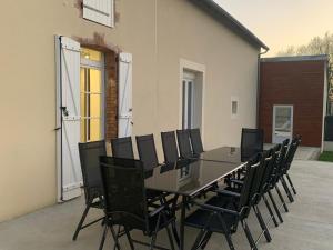 a black table and chairs in front of a building at Maison isolée avec jardin, piscine intérieure chauffée et équipements pour des vacances de rêve. - FR-1-591-330 in Orsennes