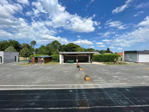 an empty parking lot with a building in the background at École rénovée avec terrasse, 3 chambres, draps, ménage et chauffage inclus - FR-1-591-344 in Paudy