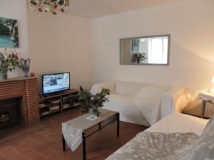 a living room with a couch and a tv at Maison avec jardin, Spa privatif à proximité de Beauval et Valençay - FR-1-591-345 in Val-Fouzon
