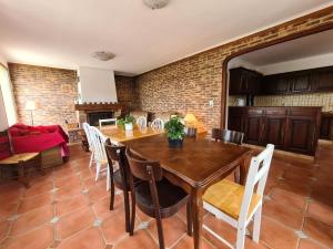 a kitchen and dining room with a wooden table and chairs at Escapade Nature : Maison et Lofts Privés avec Piscine, Étang de Pêche et Grandes Terrasses - FR-1-591-365 in Bélâbre