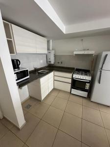 uma cozinha com armários brancos e um forno com placa de fogão em Apartment in Nueva Cba, amazing location, terrace em Córdoba