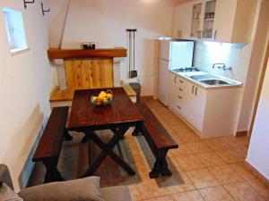 uma cozinha com uma mesa de madeira com uma taça de fruta em Secluded holiday house Postira, Brac - 22199 em Postira