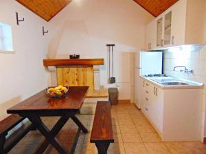 uma cozinha com uma mesa e uma taça de fruta em Secluded holiday house Postira, Brac - 22199 em Postira