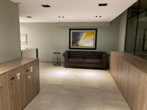 a waiting room with a couch and a painting on the wall at Andén 7 3/5 in Salta