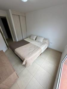 uma cama grande num quarto com piso em azulejo em Apartment in Nueva Cba, amazing location, terrace em Córdoba