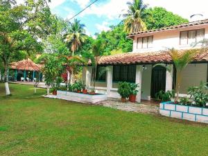 una casa con palmeras en el patio en Hermosa Finca en Doradal en Doradal