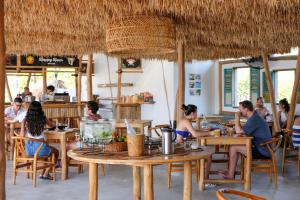a group of people sitting at tables in a restaurant at Le Pirate Gili Meno - Adults Only in Gili Meno