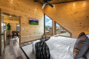 a bedroom with wooden walls and a large bed at SmokiesBoutiqueCabins would love to host you at our NEW cabin! 3 King Suites, Indoor Pool, Game Room, Lounge with 75" TV! Close to Dollywood and the Parkway! in Pigeon Forge +55 photos