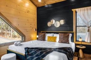 1 dormitorio con 1 cama con pared negra en SmokiesBoutiqueCabins would love to host you at our NEW cabin! 3 King Suites, Indoor Pool, Game Room, Lounge with 75" TV! Close to Dollywood and the Parkway! en Pigeon Forge