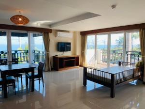 a living room with a dining table and a television at Pattawia Resort & Spa, Pranburi in Pran Buri