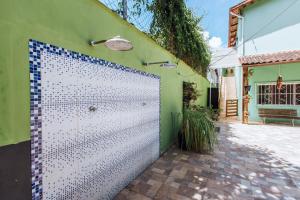 een wit hek voor een groen gebouw bij pousada formibela in Ilhabela
