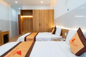 um quarto de hotel com duas camas e uma televisão em KHÁCH SẠN HÀ PHƯƠNG em Tánh Linh