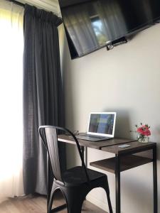 einen Schreibtisch mit einem Laptop und einem Stuhl in einem Zimmer in der Unterkunft La casona Talpen in Constitución
