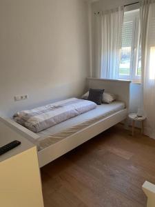 a bed sitting in a room with a window at Schönes und gemütliches Haus in mitten der Natur in Schabenhausen