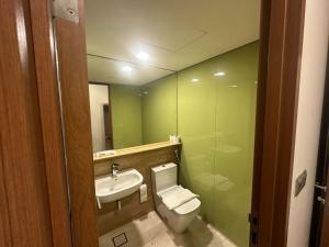 a bathroom with a toilet and a sink and a mirror at Sky Suites KL City Center in Kuala Lumpur +37 photos
