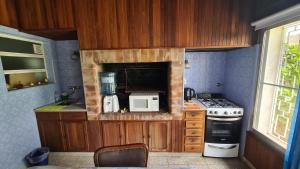 a small kitchen with a stove and a microwave at Monoambiente Cañuelas Centro calle Principal hasta 4 personas in Cañuelas