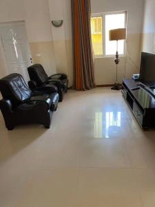 a living room with two chairs and a television at Jbct & SOLANGE APART in Praia +12 photos