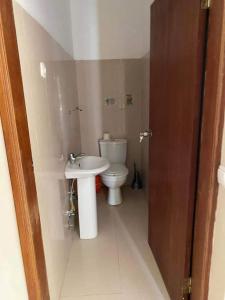 a small bathroom with a toilet and a sink at Jbct & SOLANGE APART in Praia