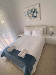 um quarto com uma grande cama branca e 2 almofadas em Central Pool-Side 2 Bedroom Apartment in Paphos em Pafos