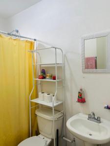 y baño con aseo blanco y lavamanos. en Alojamiento en Morelos, en Yecapixtla
