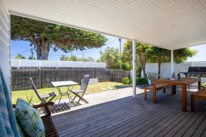 a patio with a wooden deck with a table and chairs at Sorrento Beach Cottages No.1 - in the heart of Sorrento in Sorrento