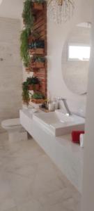 a white bathroom with a sink and a mirror at Hotel Tauari in Marabá