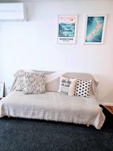 a couch in a living room with pillows on it at Short Drive to Queenstown CBD - Cosy Guesthouse with Private Entrance and King Bed in Frankton