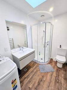 a bathroom with a shower and a sink and a toilet at Short Drive to Queenstown CBD - Cosy Guesthouse with Private Entrance and King Bed in Frankton