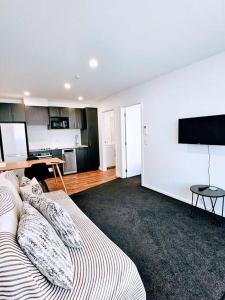 a living room with a couch and a kitchen at Short Drive to Queenstown CBD - Cosy Guesthouse with Private Entrance and King Bed in Frankton