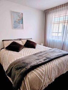 a bedroom with a large bed with a window at Short Drive to Queenstown CBD - Cosy Guesthouse with Private Entrance and King Bed in Frankton
