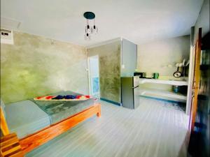 a bedroom with a bed and a kitchen in a room at baan sugaiyah in Phra Ae beach