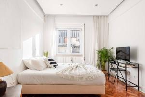 a white bedroom with a bed and a window at Soar Home in Lisbon