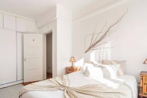 een witte slaapkamer met een bed met witte muren bij Soar Home in Lissabon
